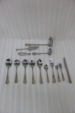 72-piece stainless steel cutlery set with gold-embossed handles arranged on a neutral linen cloth