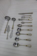 72-piece stainless steel cutlery set with gold-embossed handles arranged on a neutral linen cloth