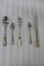72-piece stainless steel cutlery set with gold-embossed handles arranged on a neutral linen cloth