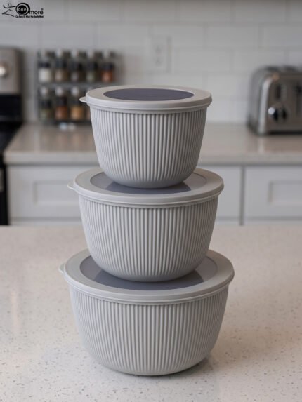 Stack of three light gray ribbed food storage containers with translucent lids on a kitchen countertop