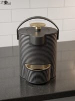 Modern ribbed matte black 2-liter hot water dispenser with gold top button, carrying handle, and gold drip tray on a kitchen countertop.