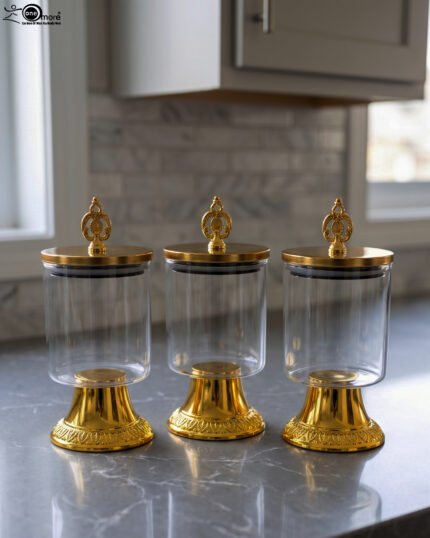 3-piece luxury clear glass storage jar set with decorative gold pedestals and ornate gold handles on a kitchen countertop