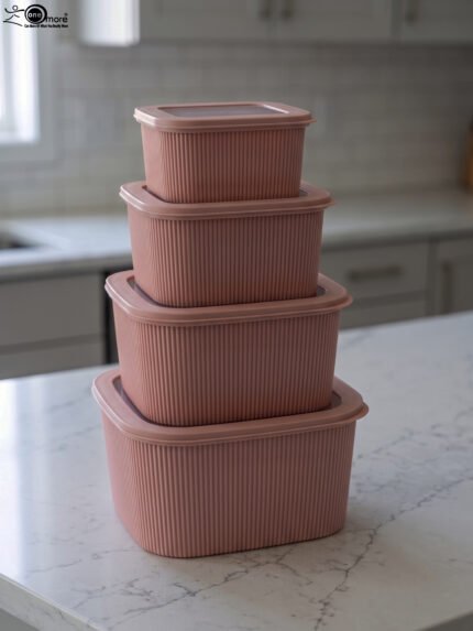 Four dusty rose ribbed plastic storage boxes with lids stacked vertically by size on a white marble kitchen countertop