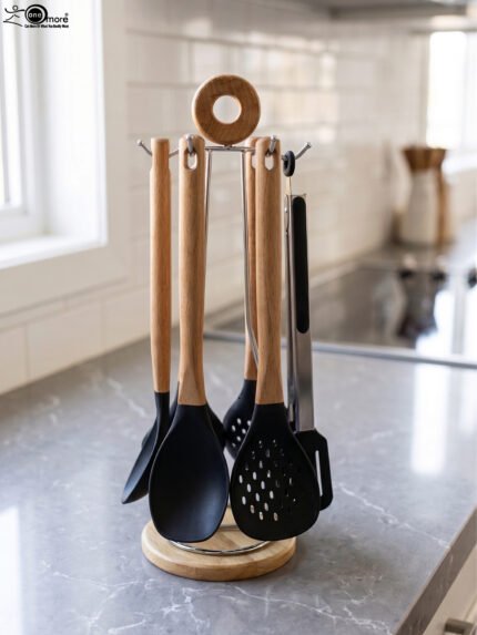7-piece black silicone cooking utensil set with wooden handles on a rotating stand sitting on a marble kitchen countertop.