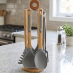 7 piece silicone cooking utensil set with wooden handles on a rotating stand