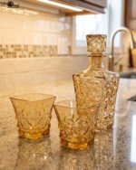 Amber-tinted 7-piece glass decanter and drinking glass set with diamond geometric texture on a marble countertop