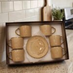 Elegantly boxed beige ceramic 6-person cup and saucer set featuring textured patterns and gold trim handles.