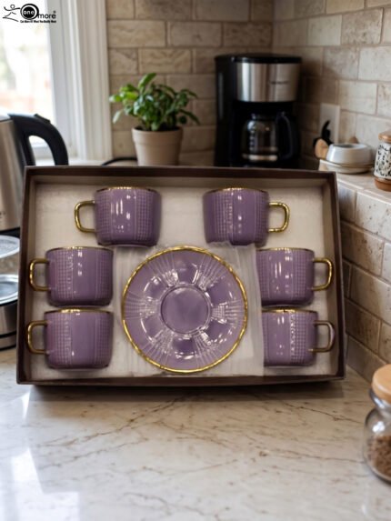 Luxury purple and gold 6-person cup and saucer set neatly arranged in a presentation box on a kitchen counter.