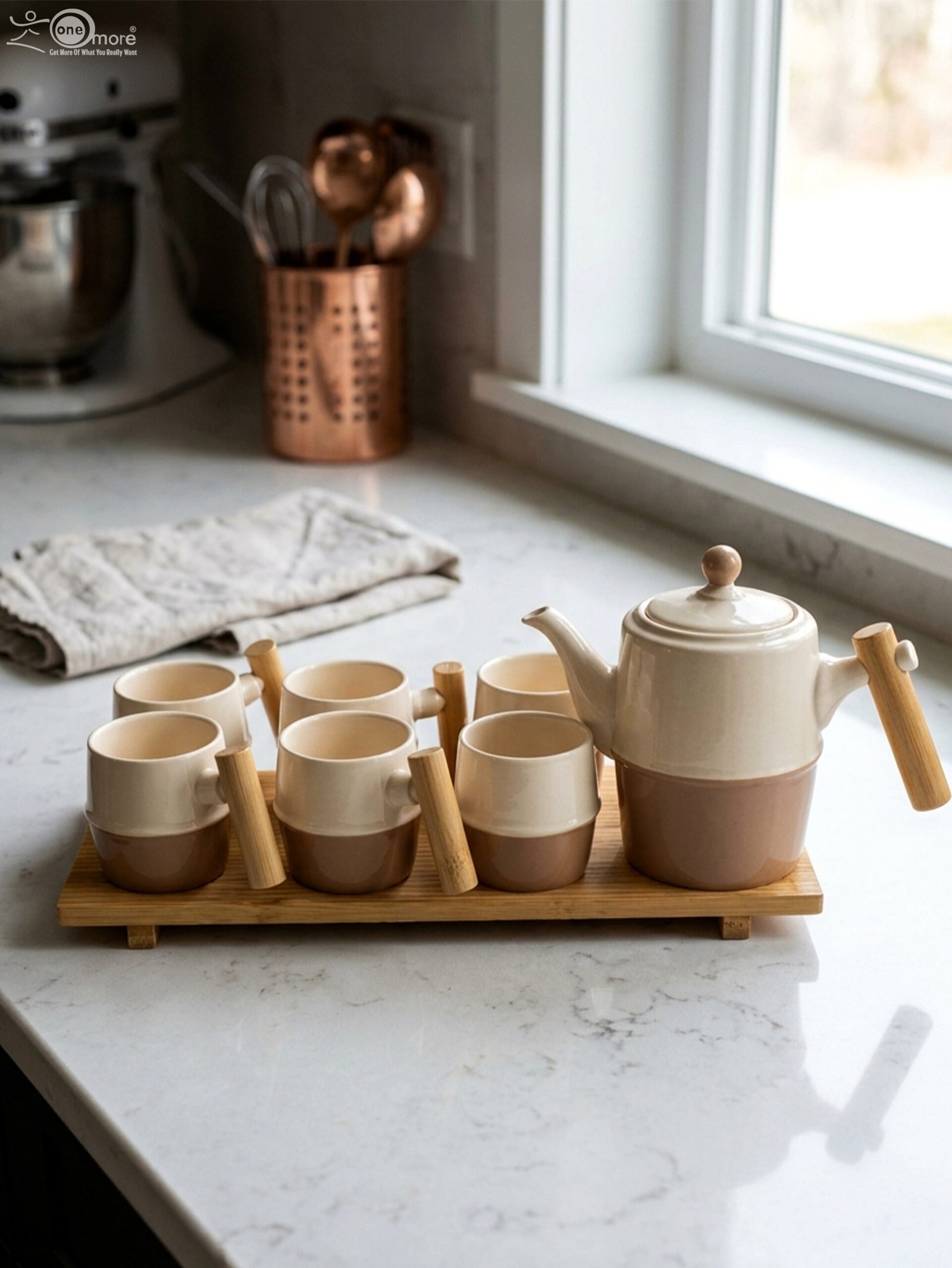 1 A complete modern tea set for 6 persons, featuring cream and mocha two-tone ceramic teapot and six matching mugs with bamboo handles, neatly organized on two bamboo serving trays on a kitchen counter.