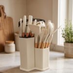 19-piece cream silicone kitchen utensil and knife set with wooden handles arranged in a matching ribbed counter holder