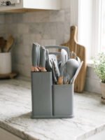 Modern grey 19-piece silicone kitchen utensil and knife set with wooden handles in a matching storage caddy on a countertop