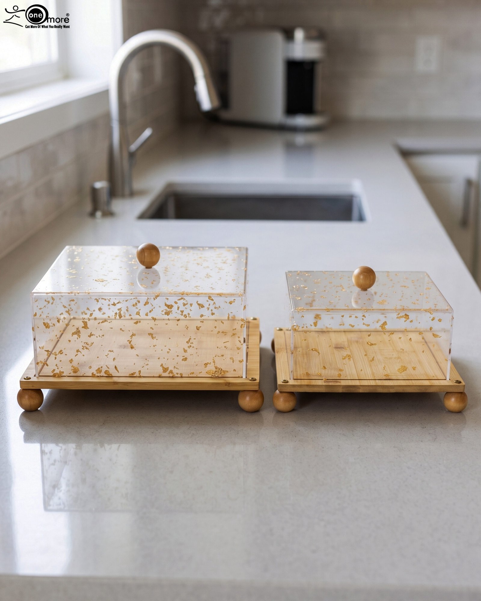 1 Square bamboo cake stand with gold flecked acrylic dome cover set on a kitchen counter