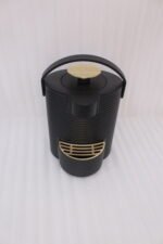 Modern ribbed matte black 2-liter hot water dispenser with gold top button, carrying handle, and gold drip tray on a kitchen countertop.