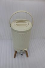 Modern 5L cream beverage dispenser with wooden legs, digital temperature display, and chrome spigot sitting on a marble kitchen countertop.