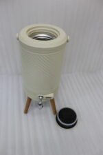 Modern 5L cream beverage dispenser with wooden legs, digital temperature display, and chrome spigot sitting on a marble kitchen countertop.