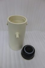 Minimalist off-white 2L insulated thermal water pitcher with carrying handle and dispenser spout on a marble kitchen countertop.