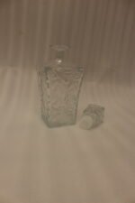 Clear crystal glass decanter bottle and matching tumbler drinking glasses with diamond pattern on kitchen counter