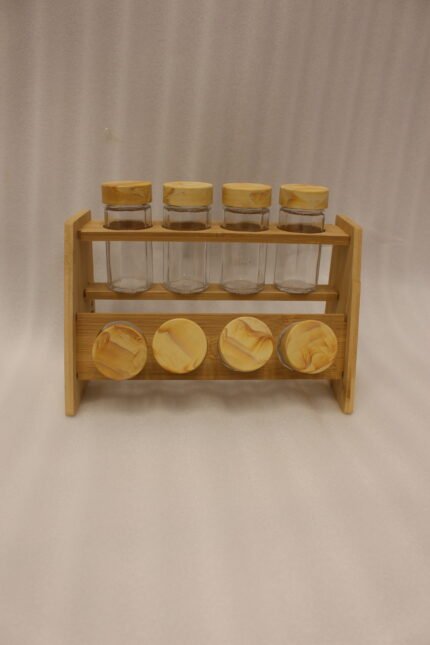 9-piece wooden spice rack with clear glass jars and matching wooden lids displayed on a white marble countertop