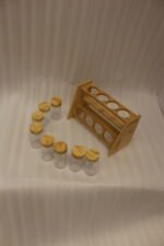 9-piece wooden spice rack with clear glass jars and matching wooden lids displayed on a white marble countertop