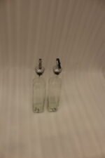 2 Pcs transparent glass oil dispenser bottles with stainless steel leak-proof pour spouts set on a marble kitchen counter