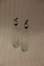 2 Pcs transparent glass oil dispenser bottles with stainless steel leak-proof pour spouts set on a marble kitchen counter