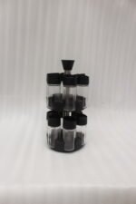 2-tier revolving spice rack set with clear glass jars and black caps on a granite countertop