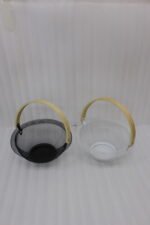 Black and white double wall mesh fruit baskets with wooden handles on a wooden countertop.