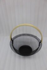 Black and white double wall mesh fruit baskets with wooden handles on a wooden countertop.