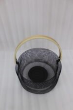 Black double-wall wire mesh fruit basket with a curved wooden handle sitting on a gray kitchen countertop.