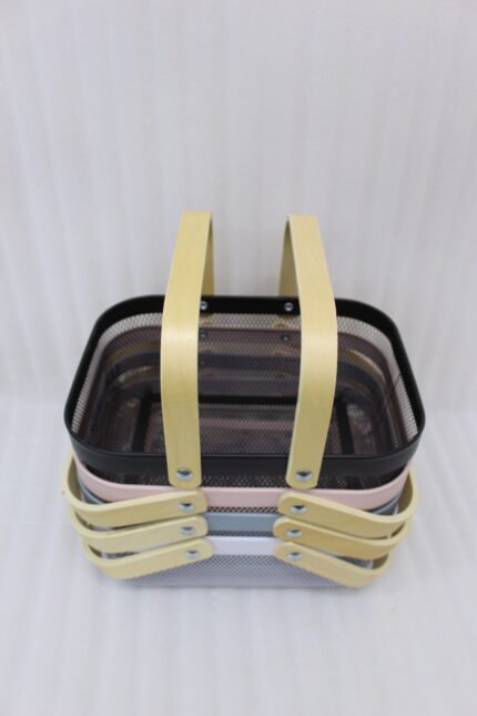 Stacked metal mesh storage baskets in black, pink, grey, and white with wooden handles on a kitchen marble countertop