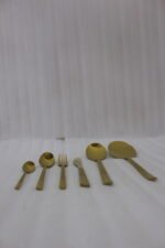 Luxury 52-piece gold stainless steel cutlery set featuring geometric textured handles lined up on a white marble surface.
