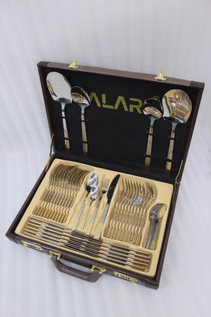 52-piece stainless steel cutlery set with gold accented textured handles arranged on a white cloth