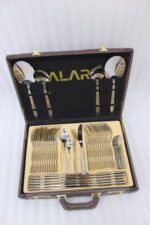 52 piece stainless steel cutlery set with silver and gold geometric pattern handles displayed on a white linen napkin