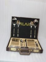 52 piece stainless steel cutlery set with silver and gold geometric pattern handles displayed on a white linen napkin