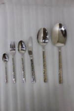 52 piece stainless steel cutlery set with silver and gold geometric pattern handles displayed on a white linen napkin