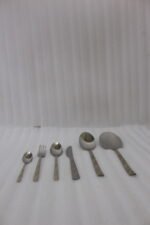 52 piece stainless steel cutlery set with silver and gold geometric pattern handles displayed on a white linen napkin