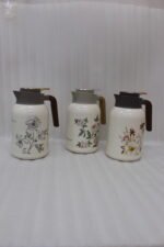 Three 2L vacuum thermal flasks with vintage floral patterns and ergonomic handles on a kitchen counter