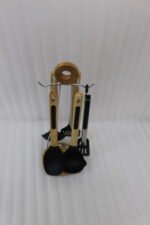 7-piece black silicone cooking utensil set with wooden handles on a rotating stand sitting on a marble kitchen countertop.