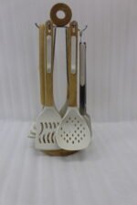 7 piece white silicone kitchen utensil set with natural wooden handles hanging on a chrome stand