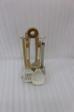 7 piece white silicone kitchen utensil set with natural wooden handles hanging on a chrome stand