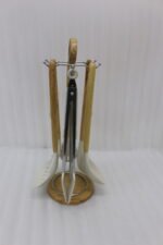 7 piece white silicone kitchen utensil set with natural wooden handles hanging on a chrome stand