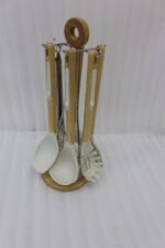 7 piece white silicone kitchen utensil set with natural wooden handles hanging on a chrome stand