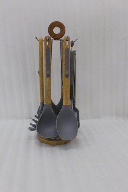 7 piece silicone cooking utensil set with wooden handles on a rotating stand