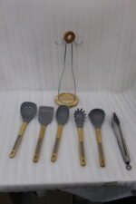 7 piece silicone cooking utensil set with wooden handles on a rotating stand