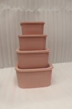 Four dusty rose ribbed plastic storage boxes with lids stacked vertically by size on a white marble kitchen countertop