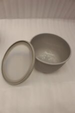 Stack of three light gray ribbed food storage containers with translucent lids on a kitchen countertop