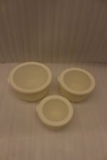 Stacked 3-piece white fluted food storage containers with clear airtight lids on a kitchen counter