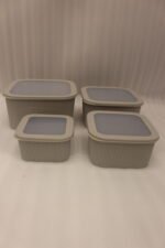 Stacked 4-piece ribbed grey plastic storage box set with fitted lids on a marble kitchen countertop.