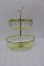 Modern 2-tier gold metal wire fruit basket holder on a wooden dining table