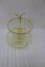 Modern 2-tier gold metal wire fruit basket holder on a wooden dining table